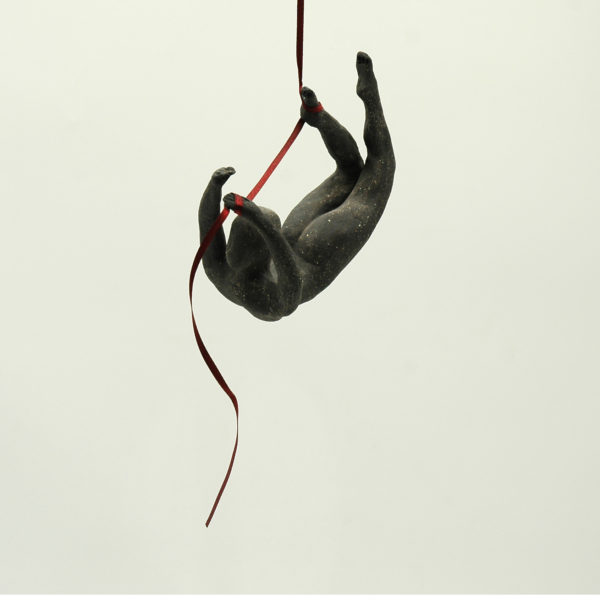 Ceramic acrobat with red ribbon